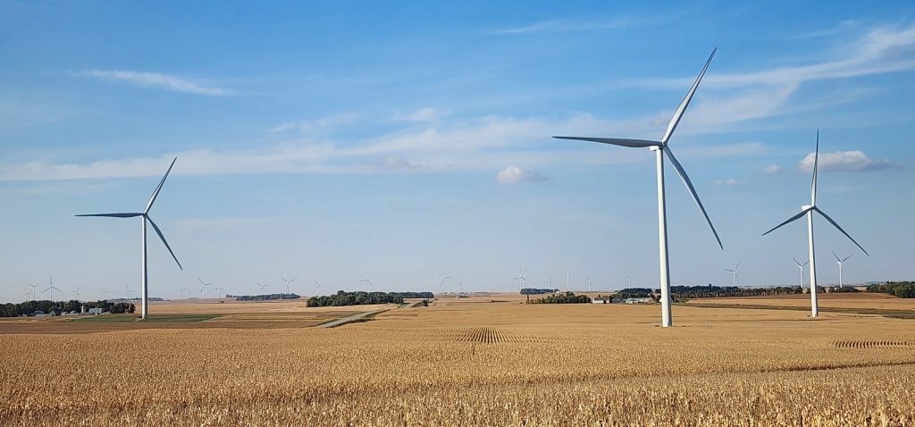 Some wind turbines in farm fields.